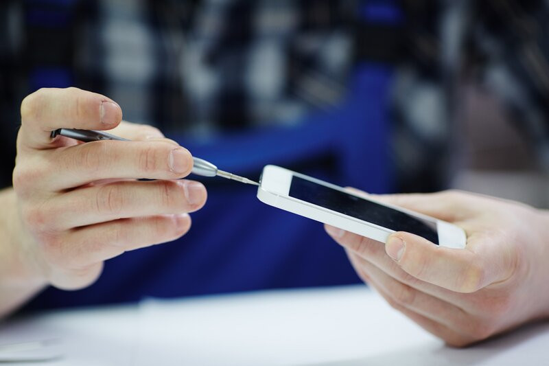 Afbeelding: Een refurbished smartphone wordt grondig geïnspecteerd, gereinigd en waar nodig worden onderdelen vervangen.
